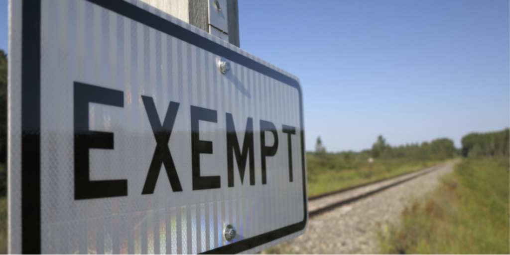 Railroad tracks in the country with a street sign that says exempt. 